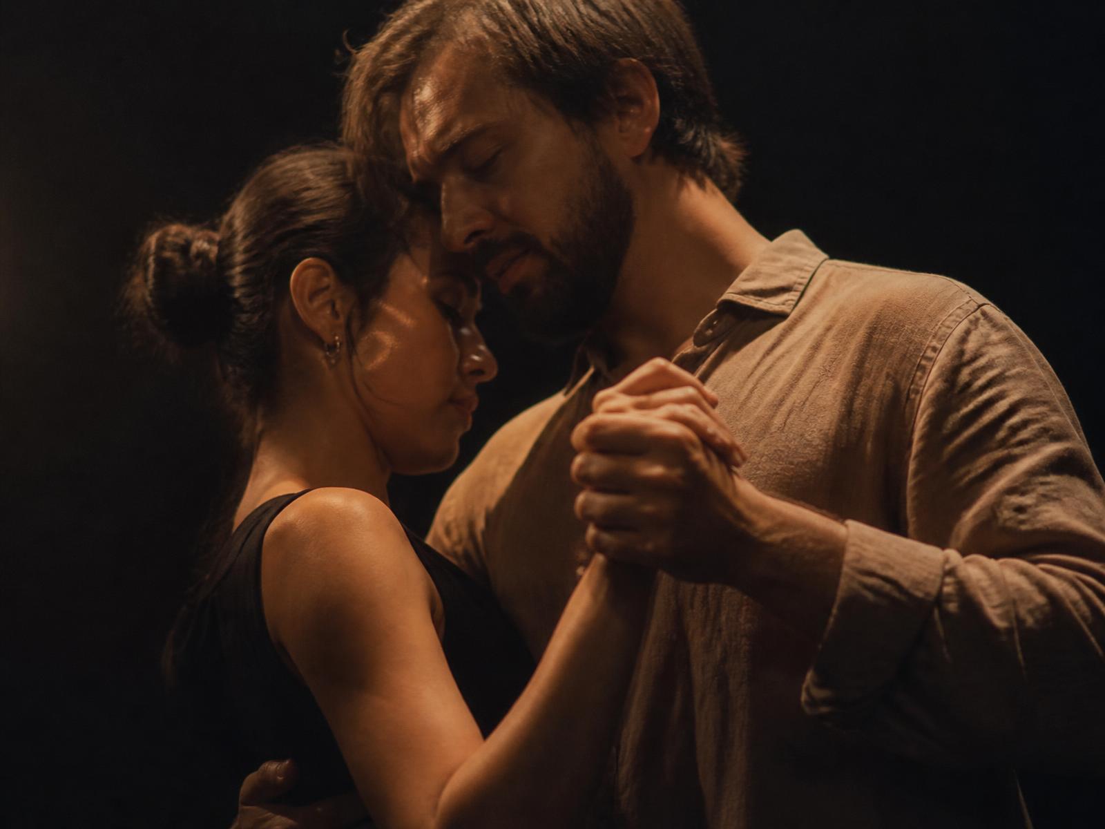A couple dancing slowly in a dark room
